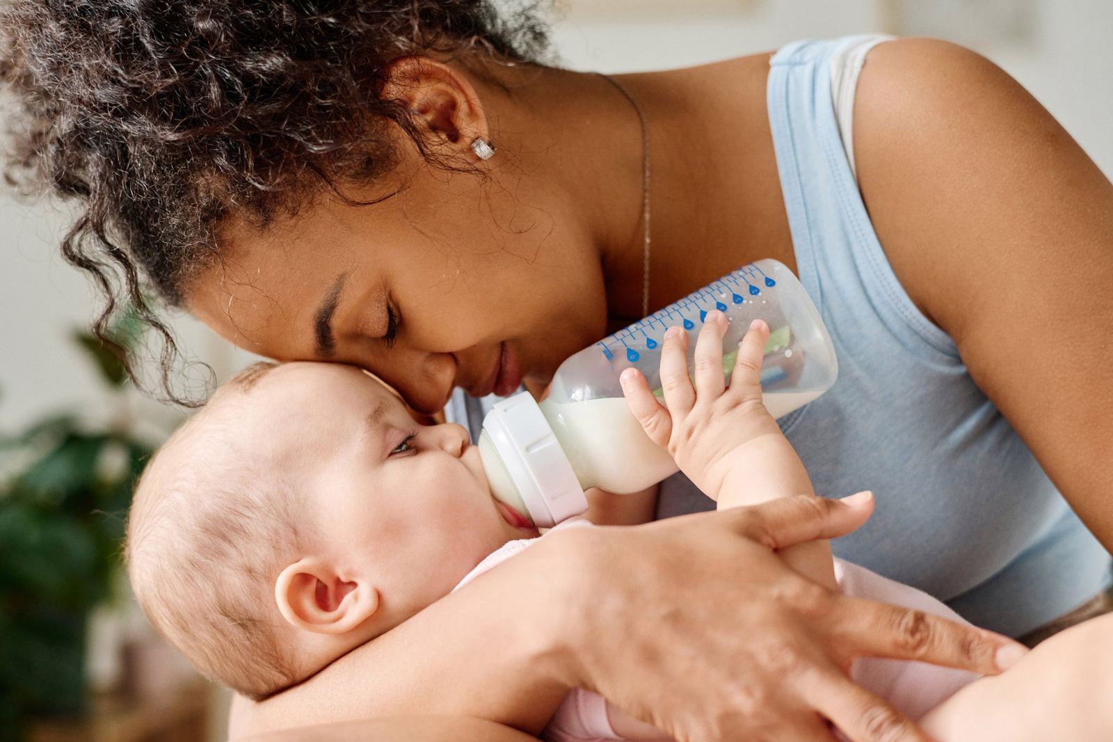 Mamá abrazando a su bebé mientras toma la mamadera